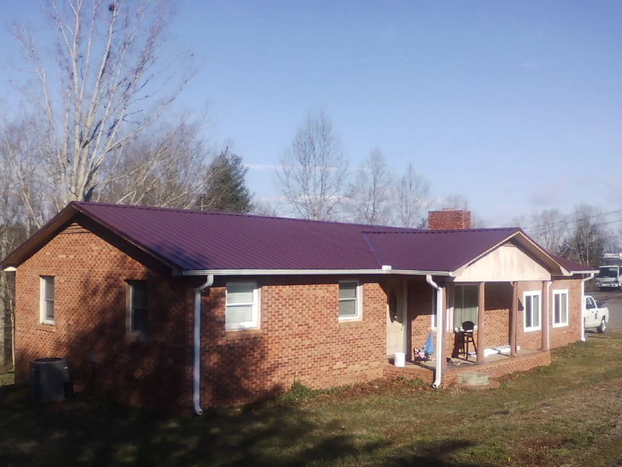 Burgundy metal roof on a brick ranch home with a new addition in Shiro