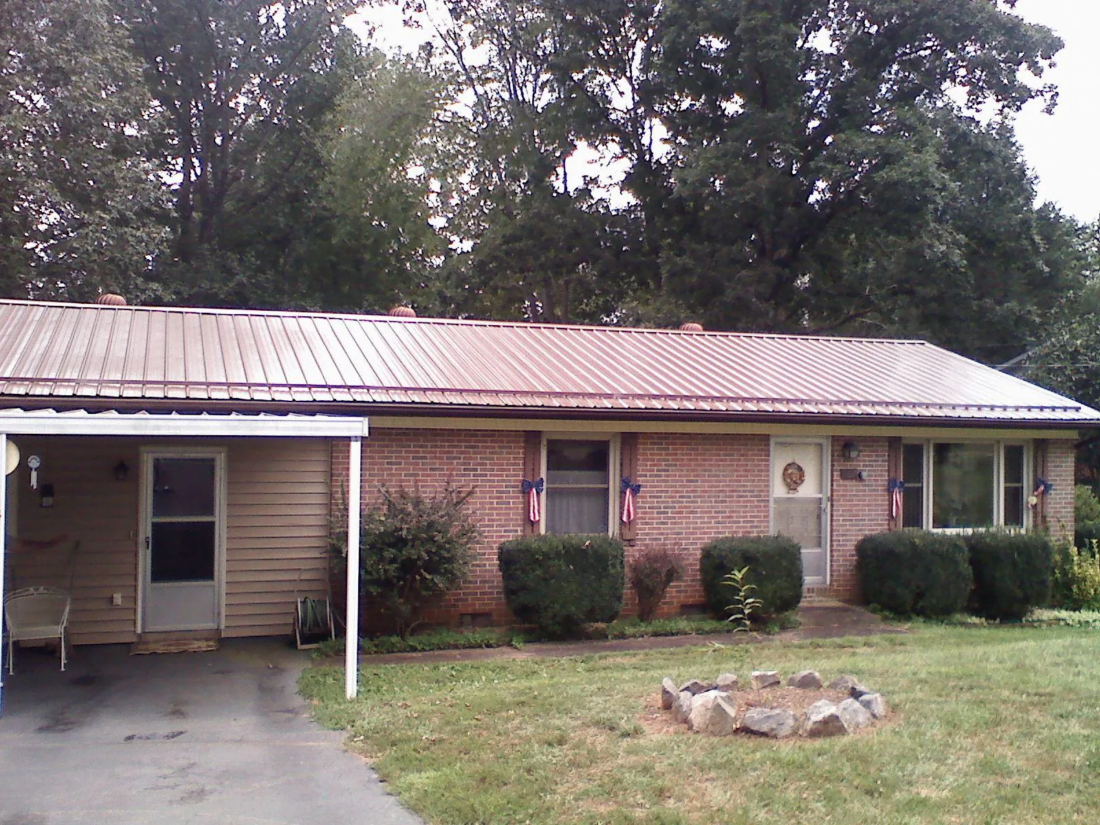 Bronze metal roof and carport on a brick ranch home — Roof Repair work by our crew in Shiro